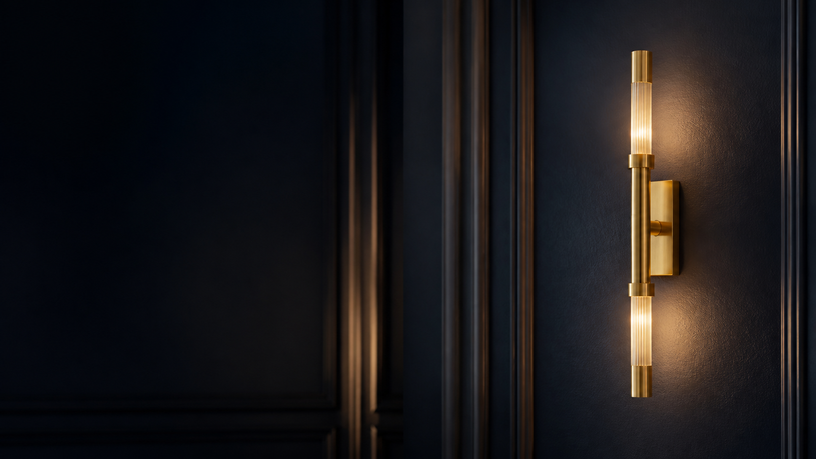 Brushed brass Domax wall sconce on a midnight-blue wall